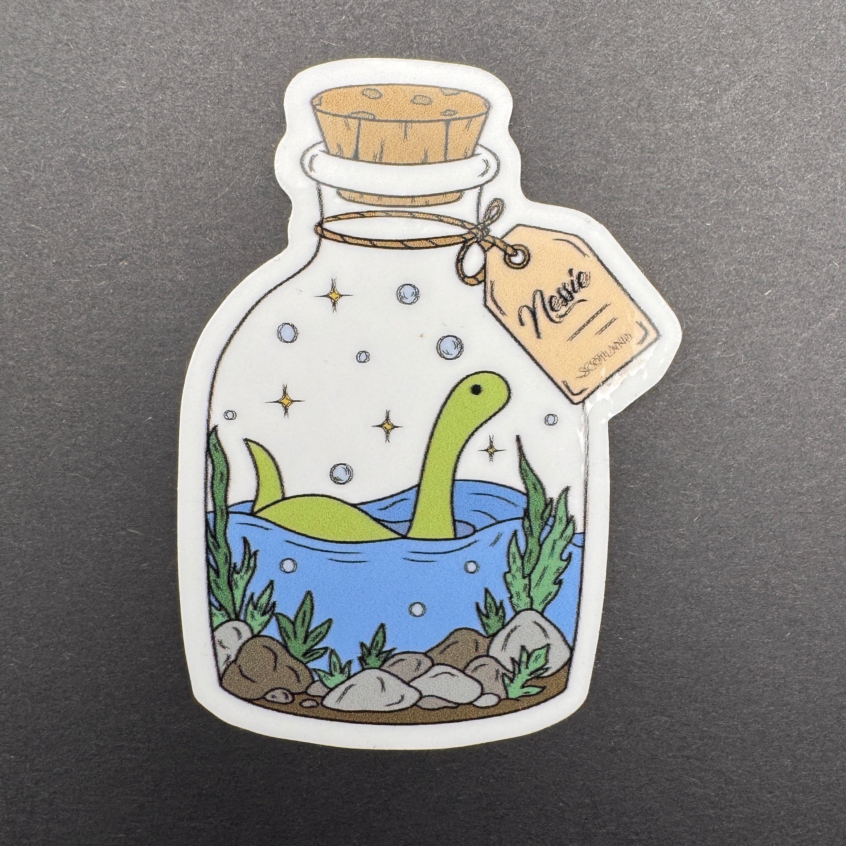 Sticker of a green dinosaur in a bottle with water and plants on a gray background