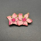 Pink orchid-shaped pin on a gray background